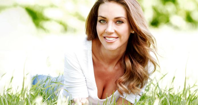 smiling woman laying in grass