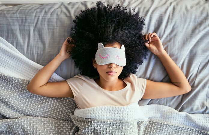 woman sleeping in bed with night mask
