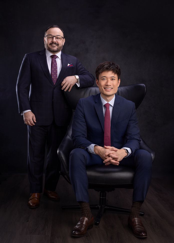 Dr. Aldo Guerra standing and Dr. Jonathan Dang sitting in chair